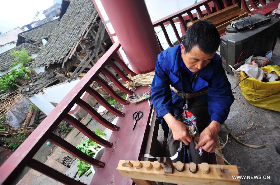 Villager Gao Yuanyou, 65, waves a straw sandal in quake-hit Yuxi Village of Lushan County, southwest China's Sichuan Province, April 23, 2013. Gao sent the straw sandals as gifts to those volunteers who came to transport relief supplies. A 7.0-magnitude jolted Lushan County on April 20. (Xinhua/Xiao Yijiu)