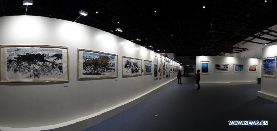 Visitors watch paintings at an art exhibition themed on Chinese ocean in Beijing, capital of China, April 24, 2013. Over 130 pieces of artworks are on display. (Xinhua/Li Xin)