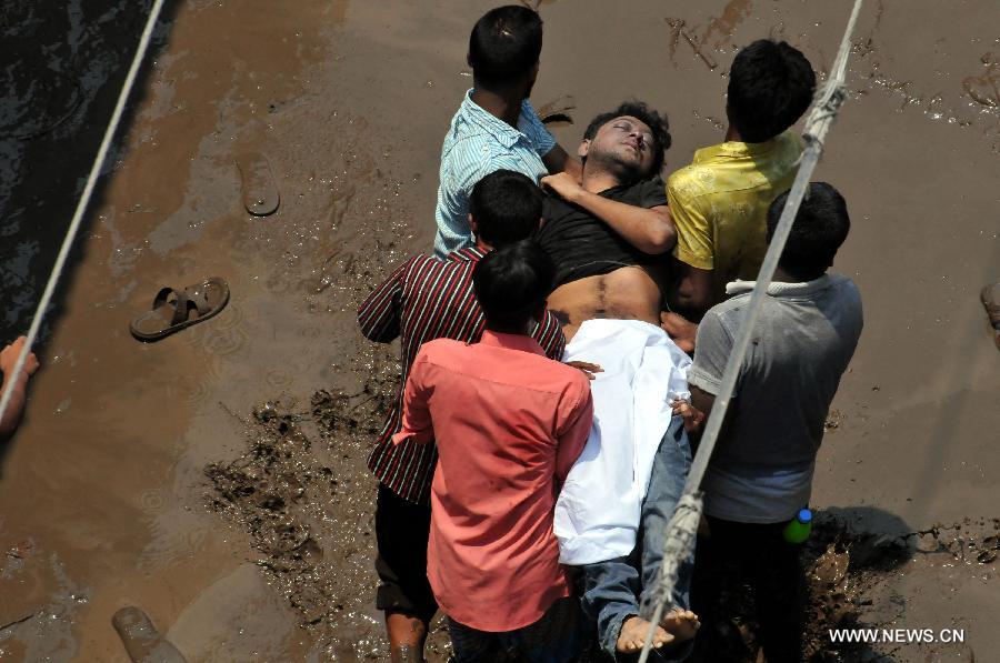 Local people carry an injured garment worker after a building collapsed in Savar, Bangladesh, April 24, 2013. At least 70 people were killed and over six hundred injured after an eight-storey building in Savar on the outskirts of the Bangladeshi capital Dhaka collapsed on Wednesday morning. (Xinhua/Shariful Islam) 
