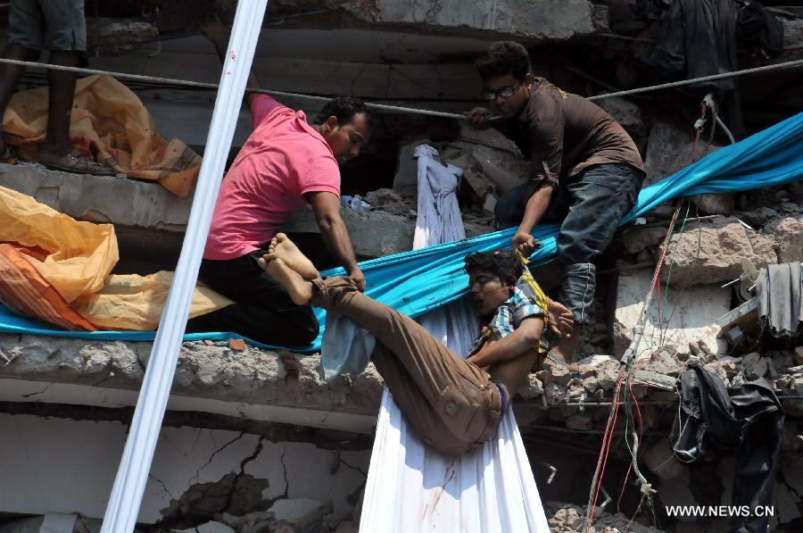 Local people remove a body from the collapsed building in Savar, Bangladesh, April 24, 2013. At least 70 people were killed and over six hundred injured after an eight-storey building in Savar on the outskirts of the Bangladeshi capital Dhaka collapsed on Wednesday morning. (Xinhua/Shariful Islam) 