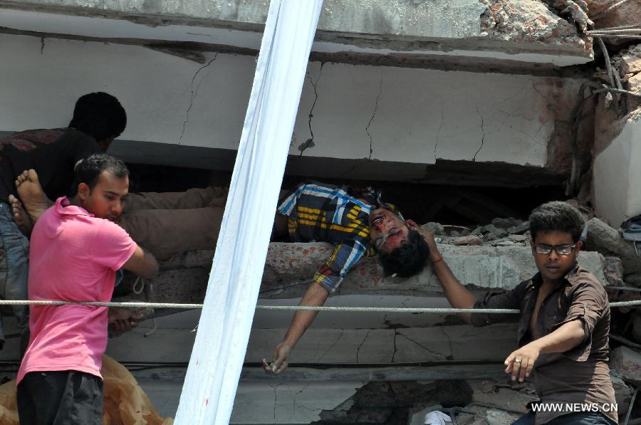 Local people remove a body from the collapsed building in Savar, Bangladesh, April 24, 2013. At least 70 people were killed and over six hundred injured after an eight-storey building in Savar on the outskirts of the Bangladeshi capital Dhaka collapsed on Wednesday morning. (Xinhua/Shariful Islam) 