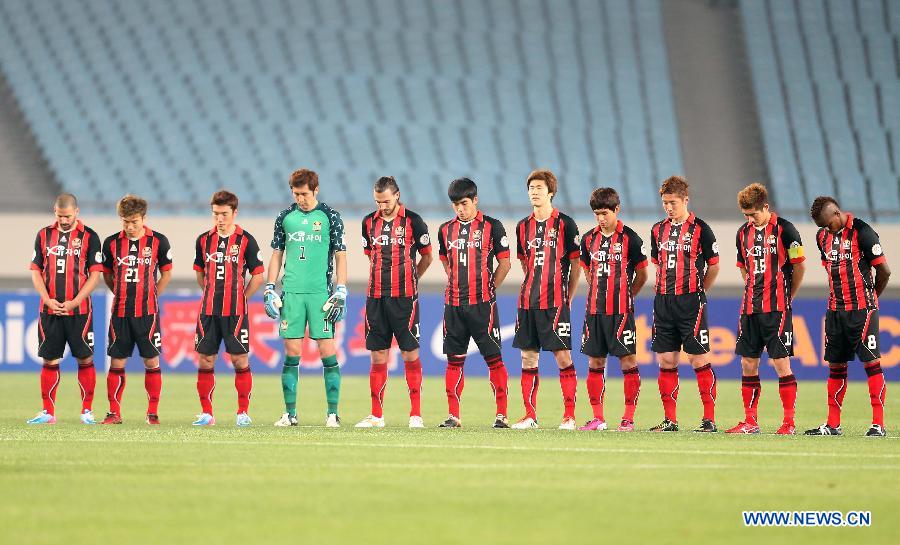 Members of South Korea's FC Seoul mourn for for the victims in the Lushan earthquake in southwest China's Sichuan Province ahead of their AFC Champions League 2013 Group E match against China's Jiangsu Sainty in Nanjing, east China's Jiangsu Province, on April 24, 2013.(Xinhua/Yang Lei)