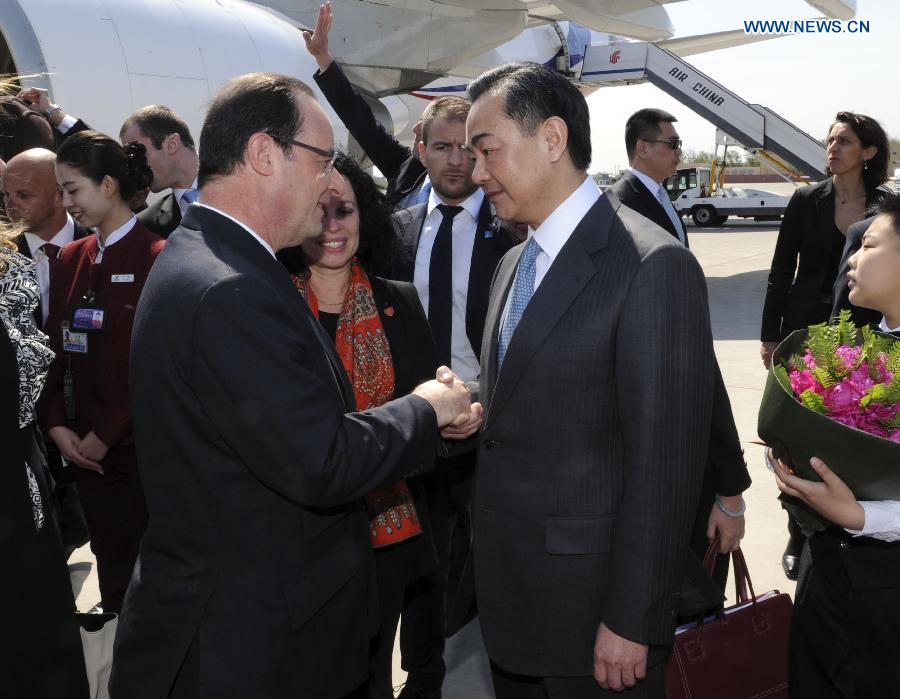 French President Francois Hollande (L) is greeted by Chinese Foreign Minister Wang Yi upon his arrival in Beijing, capital of China, April 25, 2013, for a state visit to China. (Xinhua/Zhang Duo) 