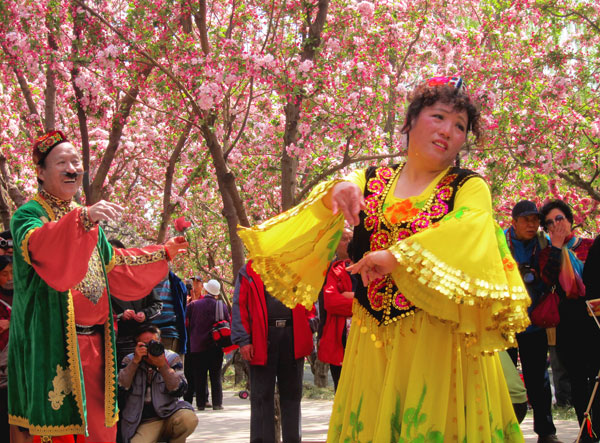 Ms Hao and her partner perform a traditional Xinjiang dance at Yuan Dadu Park, Beijing, on Wednesday, April 24. Ms Hao says, "Today the crabapple flowers are all blossoming so we came out to enjoy the flowers. Today's performance is free." [Photo: CRIENGLISH.com/William Wang]