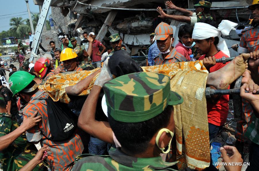 Rescuers carry a body discovered from the collapsed Rana Plaza building in Dhaka, Bangladesh, April 25, 2013. Rescue workers continued their struggle Thursday to reach many more who are feared trapped in the rubble one day after a building collapse in Savar on the outskirts of Bangladesh's capital Dhaka, with the death toll rising to 195. (Xinhua/Shariful Islam) 