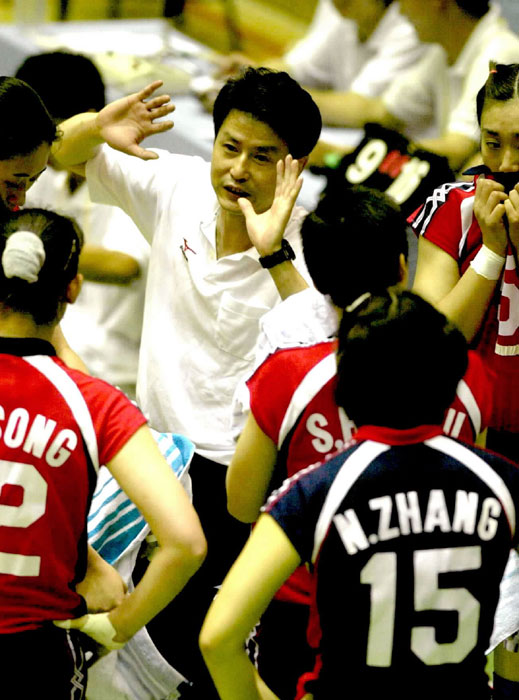 Chen Zhonghe, center, talks to players during the Shanghai stop of China International Women's Volleyball Tournament on June 6, 2001. Chen, an eastern Fujian native, was the head coach from 2001-2008 and he led the women's team to 2003 World Cup champion and Athens 2004 Olympics champion. [Photo/Xinhua]