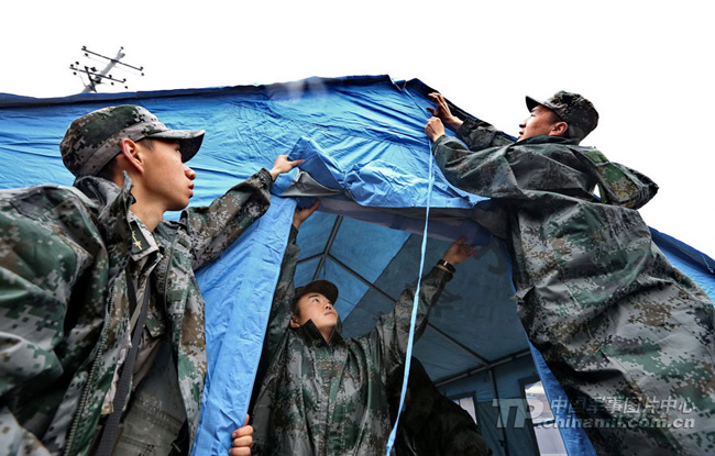 Soldiers from an artillery regiment of the 13th Group Army under the PLA Chengdu Military Area Command build up a tent for local people in the Baosheng Township of the Lushan County on April 23. The Lushan County in southwest China's Sichuan Province was severely jolted by a 7.0-magnitude earthquake on April. 20, 2013. (PLA Daily/Qiao Tianfu)