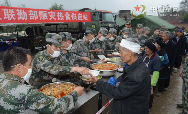 Soldiers serve local people with cooked food at a food supply point in the quake-hit Lushan County in southwest China's Sichuan Province on April 23, 2013. The Joint Logistics Department of the Chengdu Military Area Command of the Chinese People's Liberation Army set in the Longmen Town of the Lushan County a supply point to provide hot cooked food for more than 700 villagers whose homes were ruined in the 7.0-magnitude earthquake occurring in the Lushan County on April 20, 2013. (PLA Daily/Dai Tianrong)
