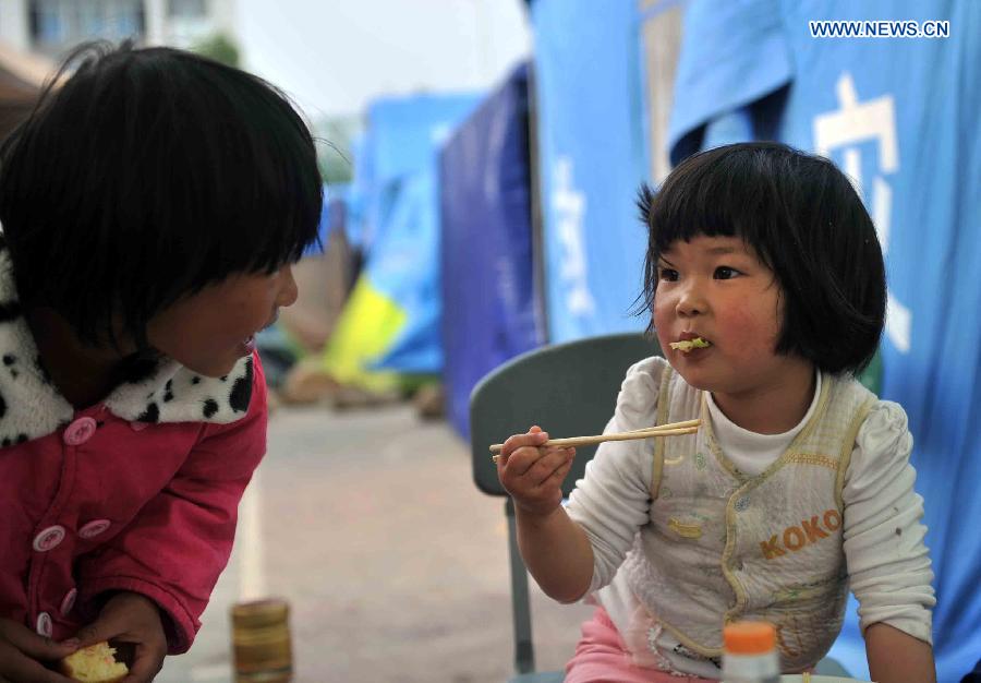 A little girl eats breakfast at a temporary settlement for quake-affected people in Lushan Middle School in Lushan County, southwest China's Sichuan Province, April 26, 2013. A 7.0-magnitude jolted Lushan County on April 20. (Xinhua/Li Wen) 