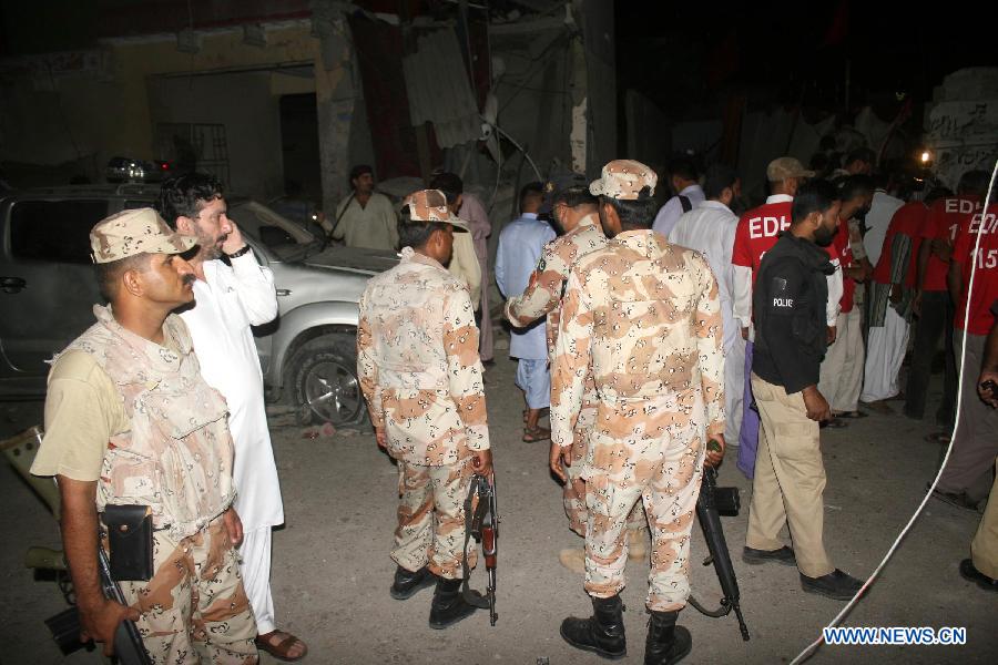 People gather at the blast site in southern Pakistani port city of Karachi on April 26, 2013. At least 11 people including a child were killed and 40 others injured on Friday night in a bomb blast that targeted a political meeting in Pakistan's southern port city of Karachi, local media and police said. (Xinhua/Masroor) 