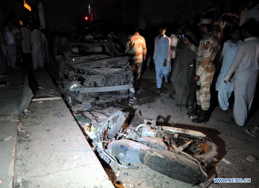 People gather at the blast site in southern Pakistani port city of Karachi on April 26, 2013. At least 11 people including a child were killed and 40 others injured on Friday night in a bomb blast that targeted a political meeting in Pakistan's southern port city of Karachi, local media and police said. (Xinhua/Masroor) 