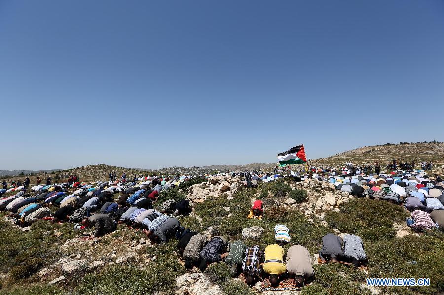Palestinian protesters pray during a protest against settlement's expansion and settlers attack in the west bank village of Dir Jrer near Ramallah on April 26, 2013. Six protesters were injured during clashes between Palestinians and Israeli soldiers. (Xinhua/Fadi Arouri)