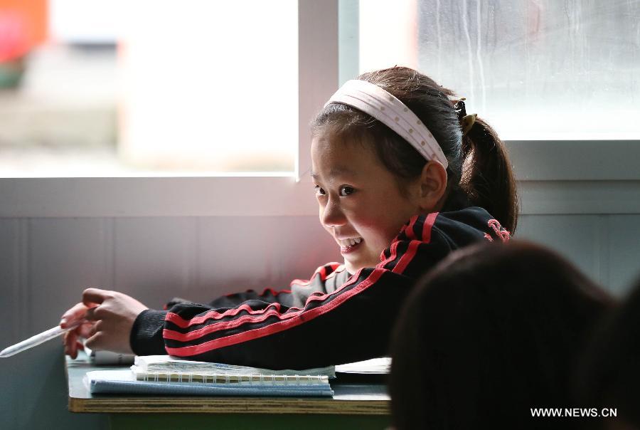 A girl smiles during a class in Baosheng Primary School in Lushan County, southwest China's Sichuan Province, April 26, 2013. The primary school was built within 28 hours by the air force troops from the People's Liberation Army (PLA) Chengdu Military Area Command (MAC), who also donated stationery and computers to students and teachers affected by the earthquake which hit Lushan County on April 20. (Xinhua/Liu Yinghua)