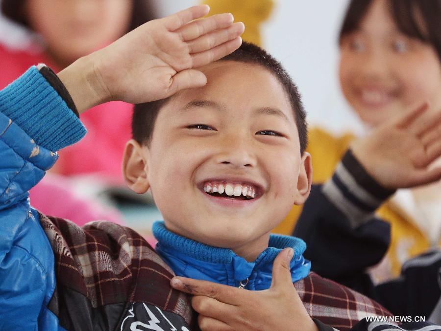 A boy salutes to soldiers from the air force in Baosheng Primary School in Lushan County, southwest China's Sichuan Province, April 26, 2013. The primary school was built within 28 hours by the air force troops from the People's Liberation Army (PLA) Chengdu Military Area Command (MAC), who also donated stationery and computers to students and teachers affected by the earthquake which hit Lushan County on April 20. (Xinhua/Liu Yinghua)