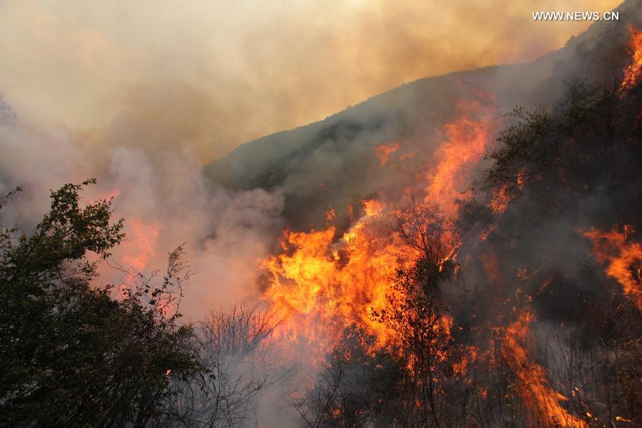 Photo taken on April 26, 2013 shows the scene of a forest fire in Qinfeng Township of Lufeng County, southwest China's Yunnan Province. Over 2,200 firefighters and service men have been mobilized to fight against a forest fire which broke out at around 16:00 (0800 GMT) on April 23. As of 16 p.m. on Friday, part of the burning area have been under control. (Xinhua/Xu Tao)