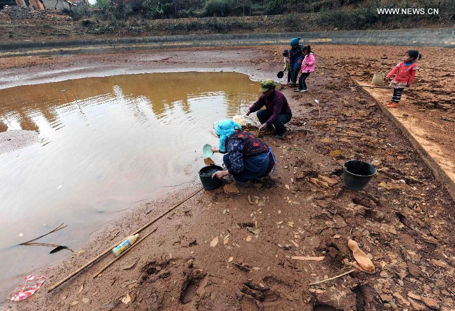 Villagers fetch water at a pond which is going dry in Duomaga Village of Kunming City, capital of southwest China's Yunnan Province, March 26, 2013. Over 12 million people were affected by the lingering drought in the province. (Xinhua/Yang Zongyou)