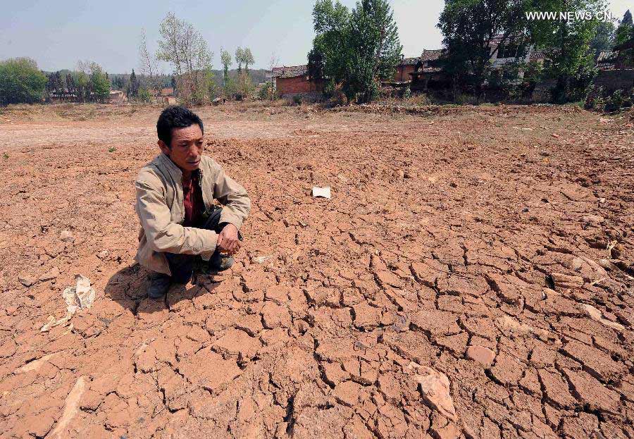 A villager looks at the dried-up pond in Qingshan Village of Qujing City, southwest China's Yunnan Province, April 8, 2013. Over 12 million people were affected by the lingering drought in the province. (Xinhua/Yang Zongyou)