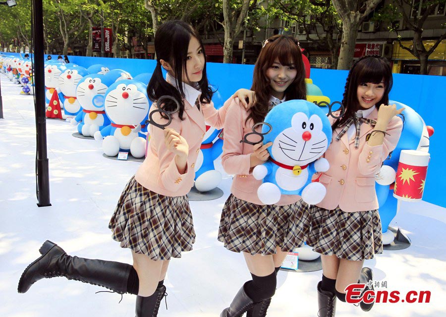 Members of the Chinese girl singing group SNH48 pose with a stuffed toy of Doraemon, a robot cat in a Japanese animation series, at Xintiandi in Shanghai, April 26, 2013. An exhibition featuring 100 Doraemons with 100 different gadgets and machines it used in the series is being held at Xintiandi until June 16. It is the largest exhibition featuring Doraemon on the Chinese mainland. (CNS/Pan Suofei)