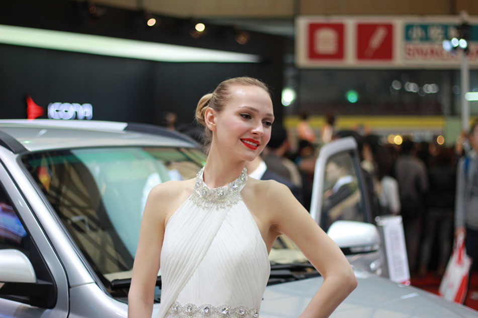 A model poses next to a Zotye car on April 21, 2013 at Shanghai International Automobile Industry Exhibition. [Liu Zheng / chinadaily.com.cn]