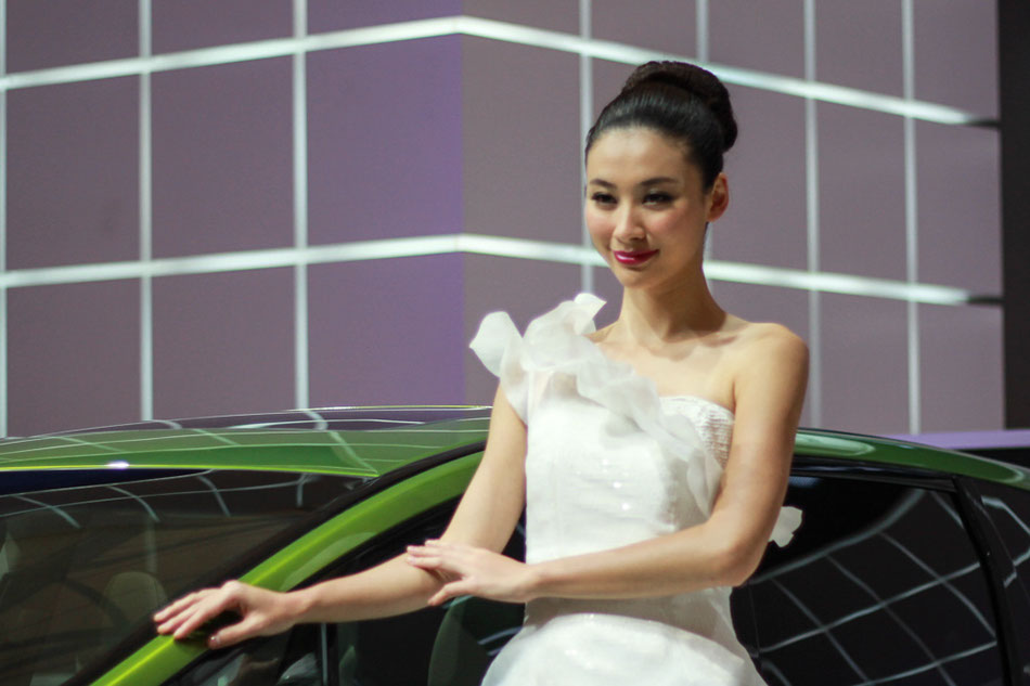 A model poses next to a Jade car on April 21, 2013 at Shanghai International Automobile Industry Exhibition. [Liu Zheng / chinadaily.com.cn]