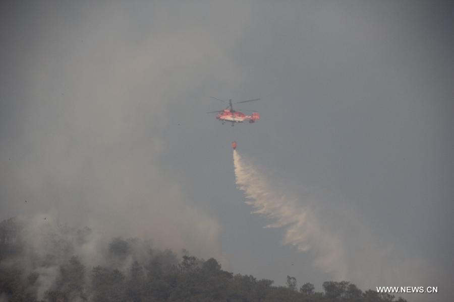 A helicopter works to put out a forest fire in Qinfeng Township of Lufeng County, southwest China's Yunnan Province, April 27, 2013. The forest fire which broke out on April 23 has been under control, and no casualties have been reported. (Xinhua/Xu Tao)
