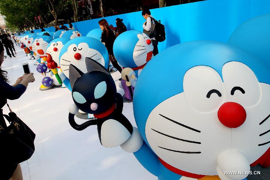 Visitors watch models of Japanese cartoon character Doraemon in Shanghai, east China, April 27, 2013. A total of 100 Doraemons models with different gestures and facial expressions were on display. (Xinhua/Chen Fei)