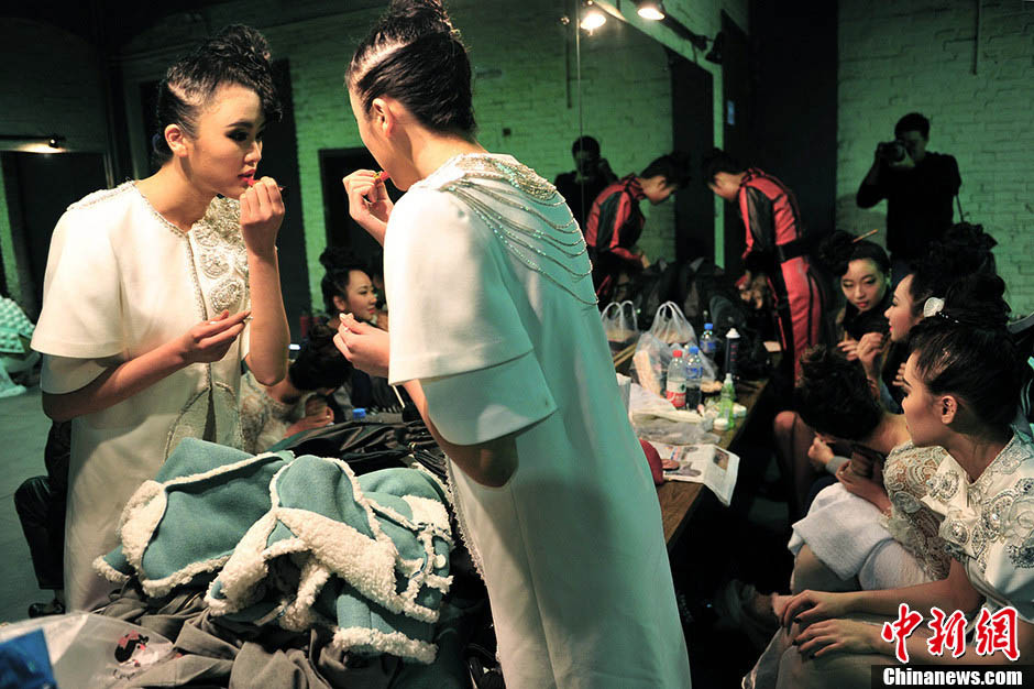 Models fix their makeup in the backstage. (Ecns.cn/Jin Shuo)