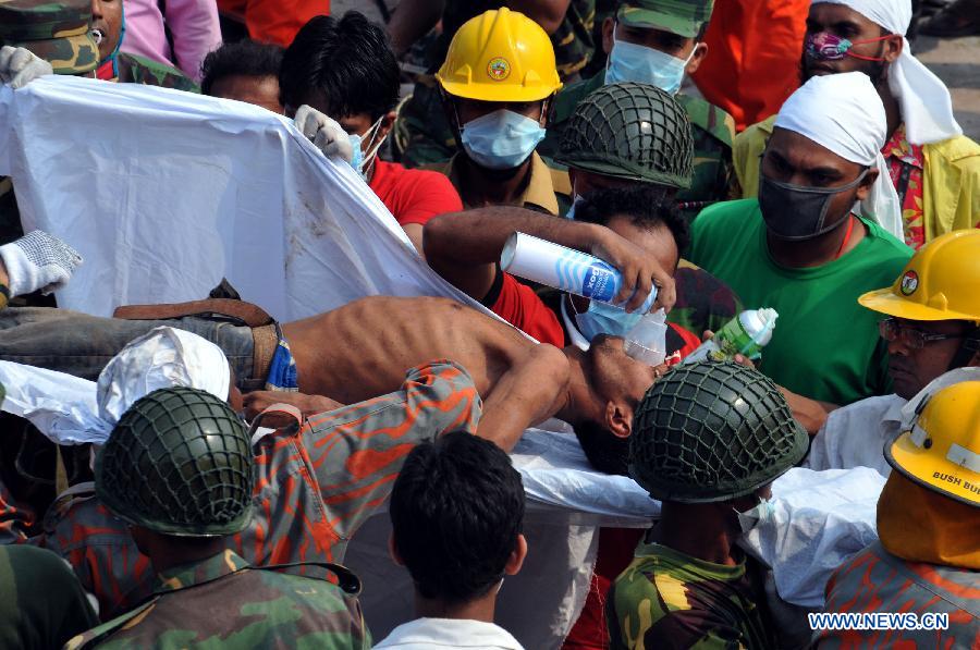 Rescuers carry a surviving garment worker out of the rubble at the collapsed Rana Plaza building in Savar on the outskirts of Dhaka, Bangladesh, April 27, 2013. In the wake of violent protests over Wednesday's building collapse that has left 332 workers dead so far, two of the owners of five ready-made garment factories housed in the collapsed Bangladesh building were arrested early Saturday. (Xinhua/Shariful Islam)