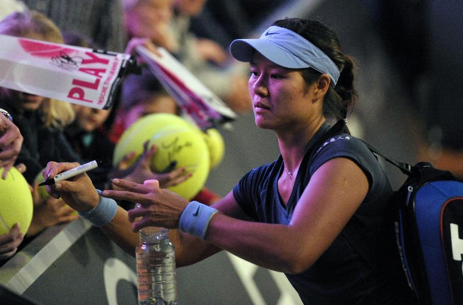 Li Na of China signs for fans after winning the semi-final match of Porsche Tennis Grand Prix against Bethanie Mattek-Sands of the United States in Stuttgart, Germany, on April 27, 2013. Li Na won 2-0. (Xinhua/Ma Ning)