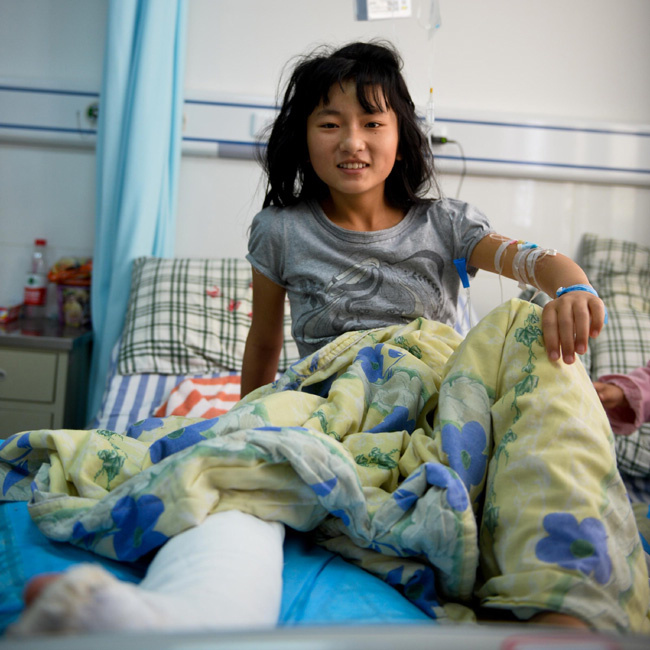 Lin Yufeng, 12, rests in a hospital for treatment in Ya'an city, Sichuan province on April 27 after being injured in the earthquake on April 20. Her father and younger brother were also injured in the quake. [Photo/Xinhua]