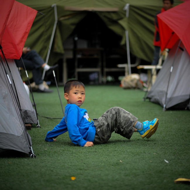A boy plays in a resettlement site for earthquake victims in Baoshan county, Southwest China's Sichuan province. Photo taken on April 24. [Photo/Xinhua]