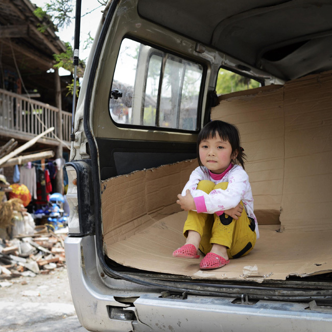 Yang Yuehang, 5, rests in a van, her temporary home besides her home destroyed by the earthquake, in Lushan county, Southwest China's Sichuan province. Photo taken on April 25. [Photo/Xinhua]