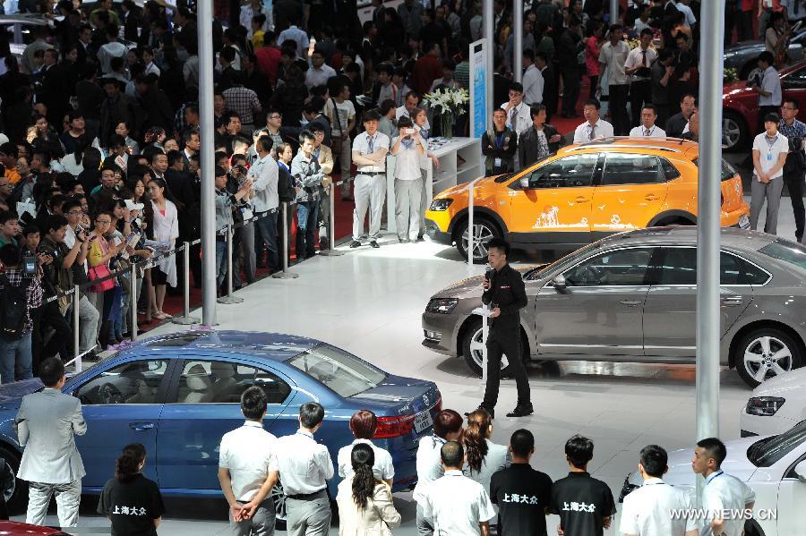 Visitors gather to watch sedans during the 5th Western China House and Automobile Fair in Yinchuan, capital of northwest China's Ningxia Hui Autonomous Region, April 28, 2013. The 7-day fair, which kicks off on April 28, attracted 30 property developers and 54 automakers. (Xinhua/Peng Zhaozhi) 
