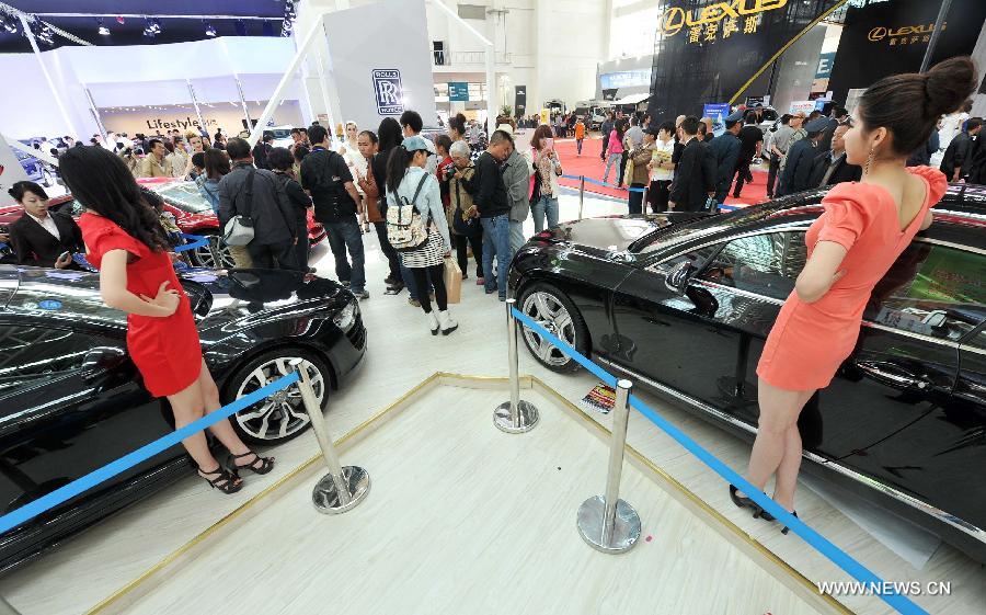 Visitors watch sedans during the 5th Western China House and Automobile Fair in Yinchuan, capital of northwest China's Ningxia Hui Autonomous Region, April 28, 2013. The 7-day fair, which kicks off on April 28, attracted 30 property developers and 54 automakers. (Xinhua/Peng Zhaozhi) 