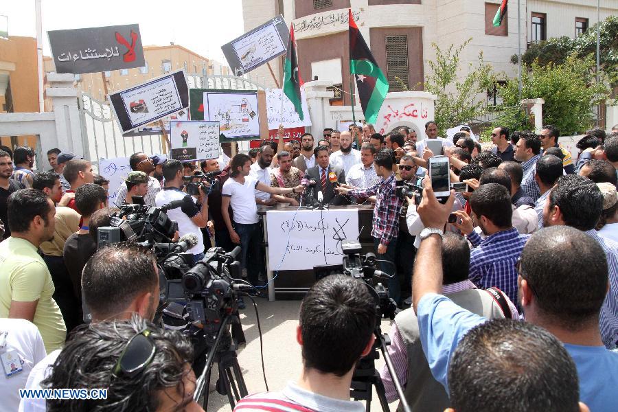 Adel Gharyani (C), a spokesman for the gunmen, speaks during a rally in Tripoli, April 28, 2013. Dozens of gunmen on Sunday surrounded Libya's foreign ministry in downtown Tripoli to demand a ban against those working under the former regime from holding senior positions. The gunmen, who claimed to have come from across the country, blocked the main streets near the foreign ministry using heavy weapons and military trucks. (Xinhua/Hamza Turkia)