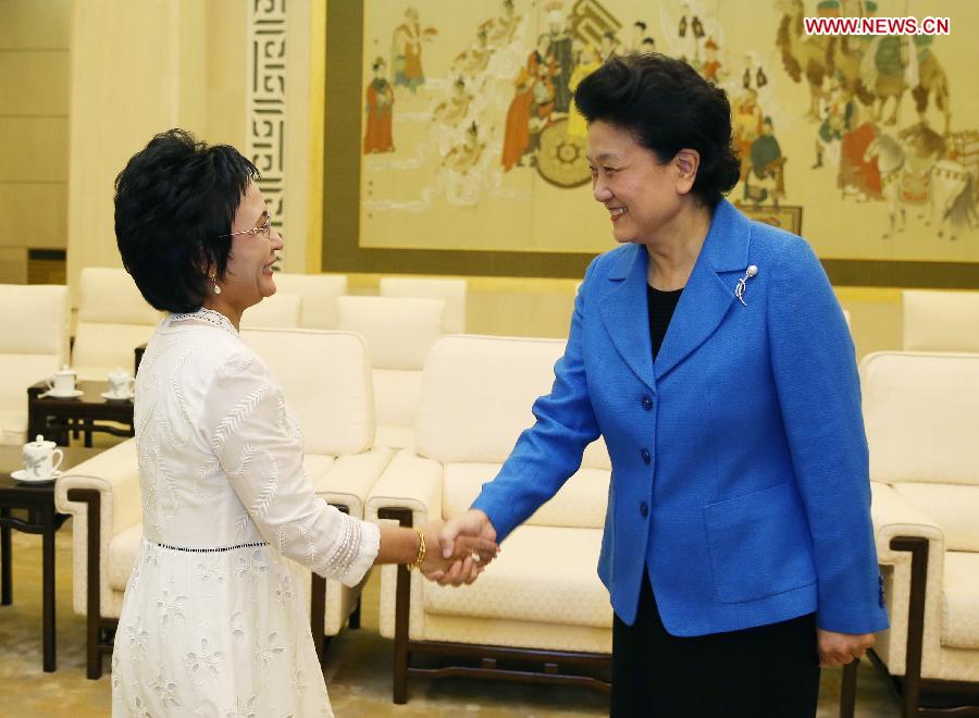 Chinese Vice Premier Liu Yandong (R) meets with her Kyrgyz counterpart Kamila Talieva during an art exhibition advocating world peace in Beijing, capital of China, April 28, 2013. (Xinhua/Yao Dawei)