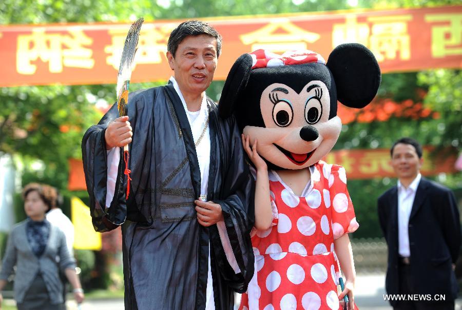 A student in a Minnie Mouse costume poses for photo with her teacher dressed as Zhuge Liang, an ancient Chinese counsellor known for his wisdom, during a costume parade in Tianyuan High School in Shanghai, east China, April 28, 2013. Teachers and students of the school dressed themselves as various real and fictional figures for a cross-culture costume parade here on Sunday. (Xinhua/Lai Xinlin) 
