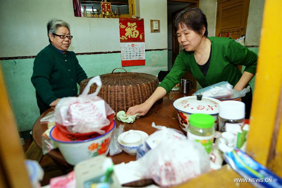 A volunteer (R) helps an old woman clean her house for free in Jin'an District of Fuzhou, capital of southeast China's Fujian Province, April 27, 2013. A total of 435 community service centers have been set up in Fuzhou since 2008 to provide daily care and entertainment activities for senior citizens. (Xinhua/Zhang Guojun) 