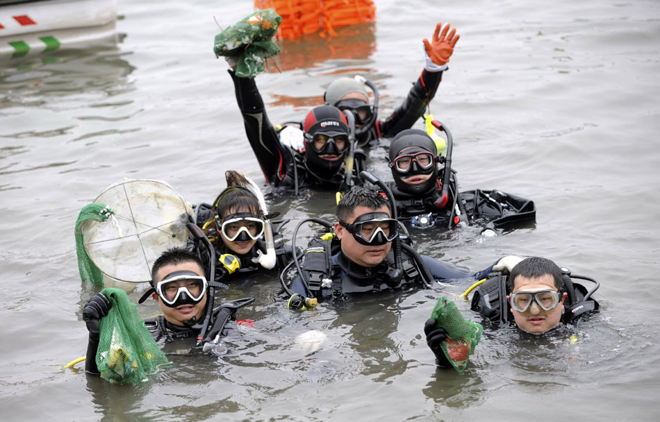 Volunteers present garbage salvaged from the bottom of a lake in Beijing’s Beihai Park to mark the 44th Earth Day, April 22, 2013. (Photo/Xinhua)
