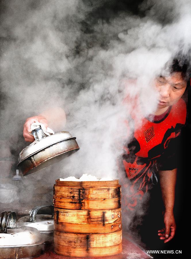 A snack bar owner prepares food for costumers in Sanhe Town of Feixi County, east China's Anhui Province, April 24, 2013. The Sanhe Ancient Town, which has a history of more than 2,500 years, is a typical "ancient town full of rivers and lakes, together with small bridges, flowing water and local dwellings." (Xinhua/Wang Song)