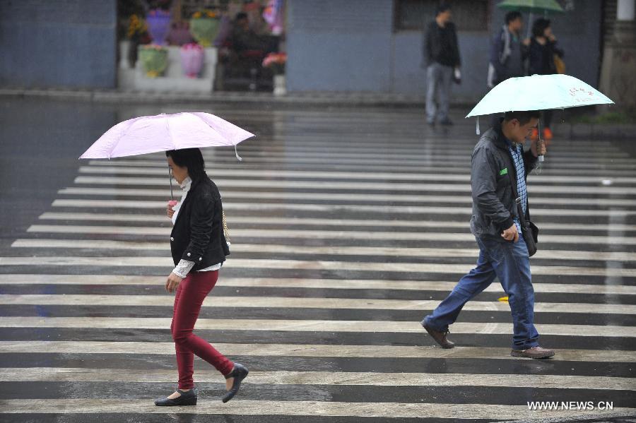People walk in rain near Tingjin Road in Ya'an City, southwest China's Sichuan Province, April 29, 2013. According to China Meteorological Administration, Ya'an is one of the most rainy city in Sichuan in May. Experts remind on secondary disasters in Ya'an, which was hit by a 7.0-magnitude earthquake on April 20, 2013. (Xinhua/Lu Peng)