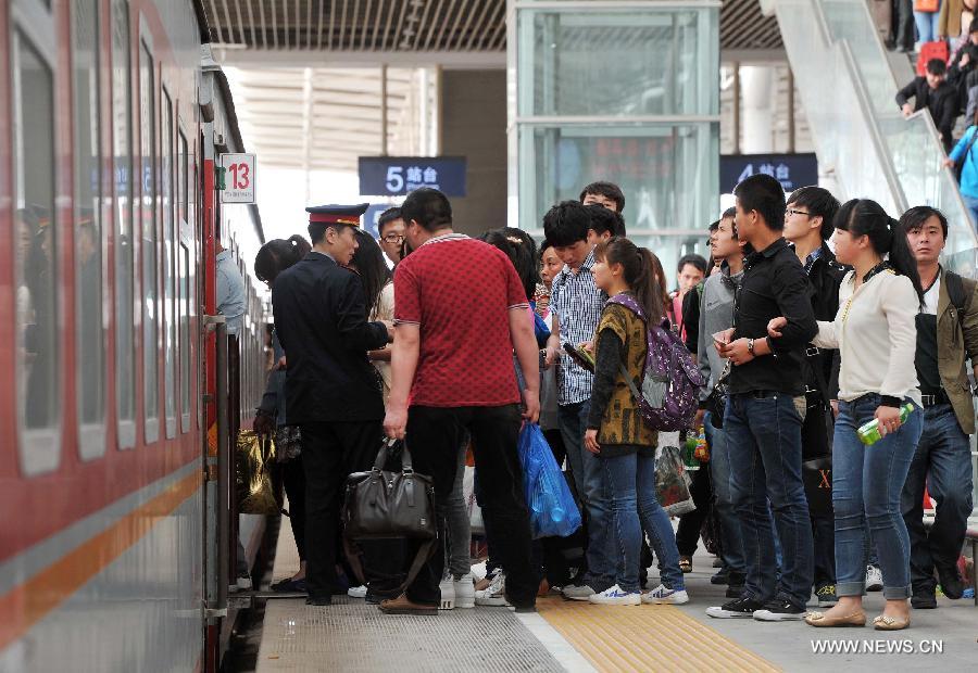 Passengers line up to board their trains in Yinchuan Railway Station in Yinchuan, capital of northwest China's Ningxia Hui Autonomous Region, April 28, 2013. China sees a travel rush around the country as the three-day May First national holiday comes around the corner. (Xinhua/Ding Ting)