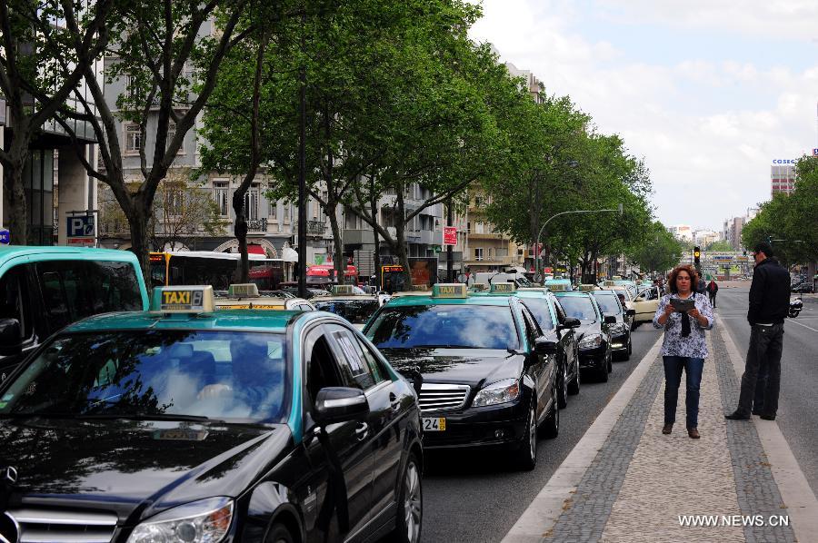 Taxis are seen on the street in Lisbon, Portugal, on April 29, 2013. Thousands of Portuguese taxi drivers drove their car into Lisbon on Monday in protest against government's decision to shift the transportation of non-emergency patients by them to firefighting department. (Xinhua/Zhang Liyun)  