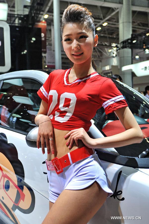 A model poses for photos with a sedan at Fuzhou Auto Fair in Fuzhou, capital of southeast China's Fujian Province, April 29, 2013. (Xinhua/Zhang Guojun)
