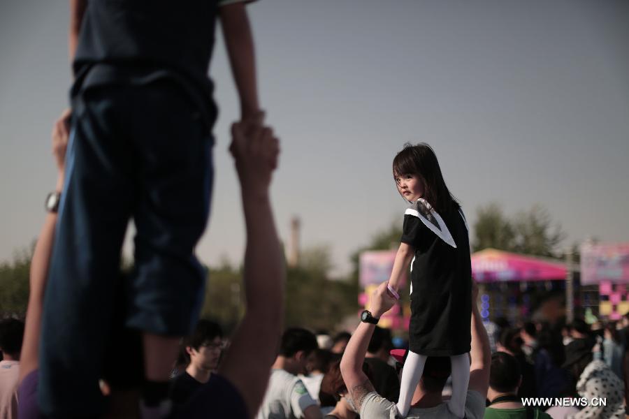 Young audiences stand on elder's shoulders at the Strawberry Music Festival in Beijing, capital of China, April 29, 2013. The three-day 2013 Strawberry Music Festival kicked off here on Monday, attracting more than 160 music bands from across the world to perform on stages of eight different styles. (Xinhua/Yao Jianfeng)
