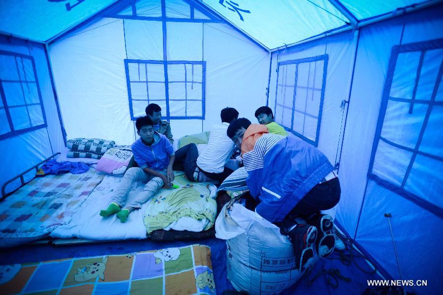 Students are seen in their temporarily-erected dormitory at Tianquan Middle School in Tianquan County, southwest China's Sichuan Province, April 29, 2013. The earthquake-hit region in Sichuan Province received a rainfall on April 29, but the rain did not affect those students who have resumed their classes in fabricated houses. (Xinhua/Li Qiaoqiao) 