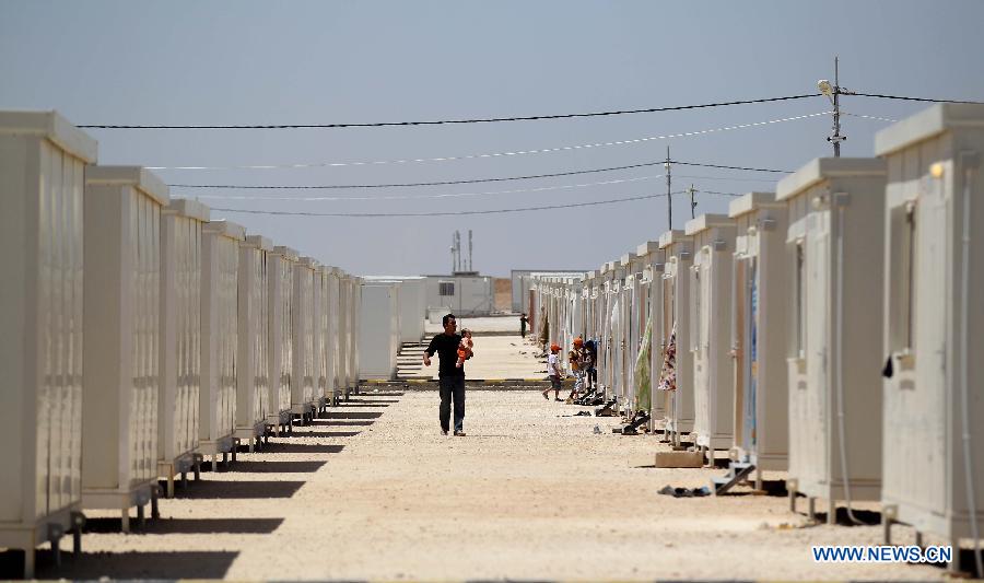 Syrian refugees walk inside the Mrajeeb Al Fhood refugee camp, 20 km (12.4 miles) east of the city of Zarqa, April 29, 2013. The Mrajeeb Al Fhood camp, with funding from the United Arab Emirates, has received about 2500 Syrian refugees so far, according to the Red Crescent Society of the United Arab Emirates. (Xinhua/Mohammad Abu Ghosh)