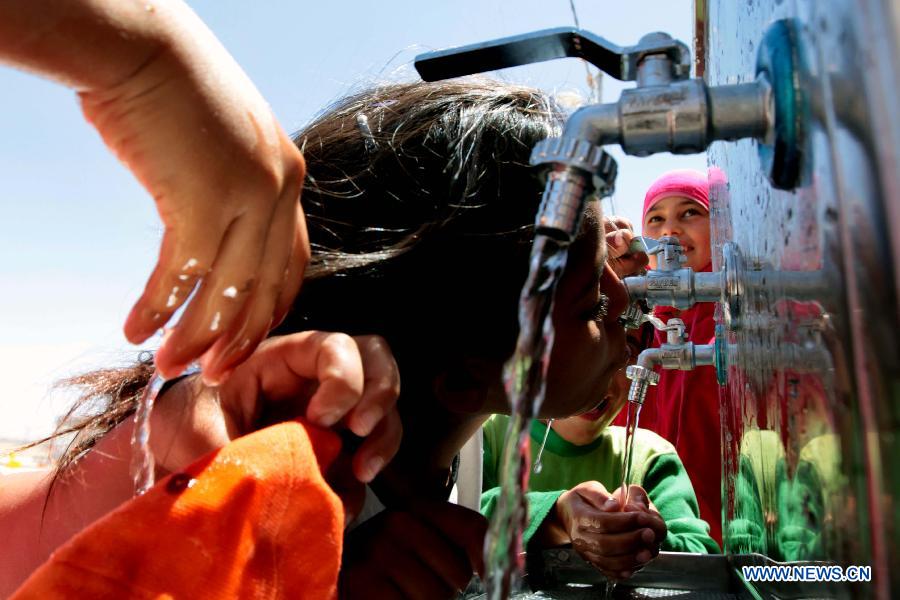 Syrian refugee children play with water at the Mrajeeb Al Fhood refugee camp, 20 km (12.4 miles) east of the city of Zarqa, April 29, 2013. The Mrajeeb Al Fhood camp, with funding from the United Arab Emirates, has received about 2500 Syrian refugees so far, according to the Red Crescent Society of the United Arab Emirates. (Xinhua/Mohammad Abu Ghosh)