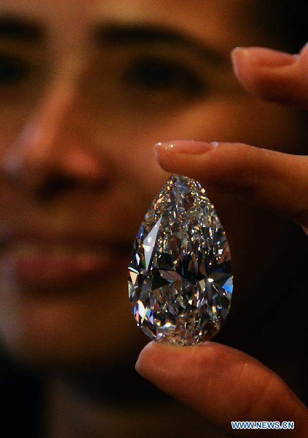 A worker shows the 101.73-carat diamond to the media at the Christie in Geneva, Switzerland, April 30, 2013. Christie will hold spring sale of Jewels auction in Geneva on May 15, 2013. Led by a truly sensational pear-shaped, D colour, flawless diamond of 101.73 carats, the sale will reach to an estimated combined total of 65 million dollars. This Type IIA Flawless gem was found at the Jwaneng mine in Botswana and took 21 months to polish. This gemstone is estimated to be sold at a price between 20 to 30 million dollars and the successful buyer will have the privilege of endowing the diamond a name. (Xinhua/Wang Siwei)