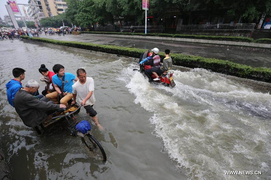 People wade through a flooded road in Guilin of southwest China's Guangxi Zhuang Autonomous Region, April 30, 2013. Heavy rainfall hit many places in Guangxi on April 29 and 30. (Xinhua/Zhao Jiazhi)